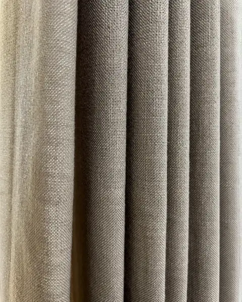 Close-up detail of textured linen-look drapery fabric with soft vertical folds