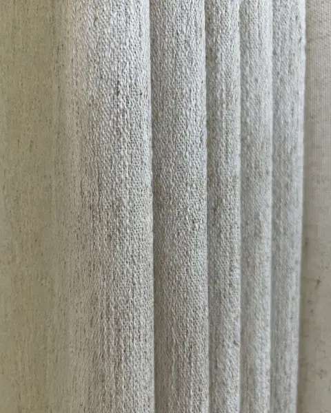 Close-up detail of textured linen-look drapery fabric with soft vertical folds