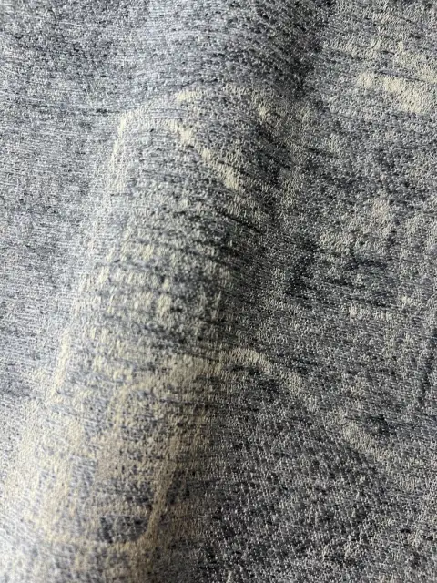 Mottled blue beige textured woven drapery fabric closeup, heavy linen look curtain material